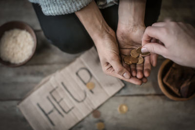 Woman giving money to poor beggar